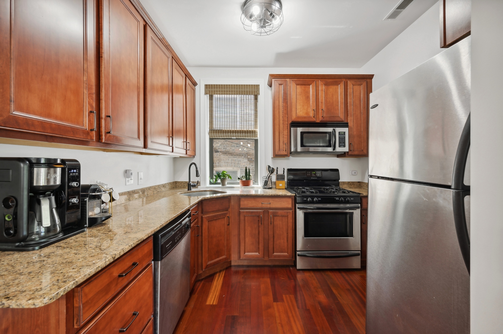 1610 West Byron Street, Unit 2 Chicago, IL 60613 - Photo 10 of 21 a kitchen with granite countertop stainless steel appliances a refrigerator stove top oven and sink