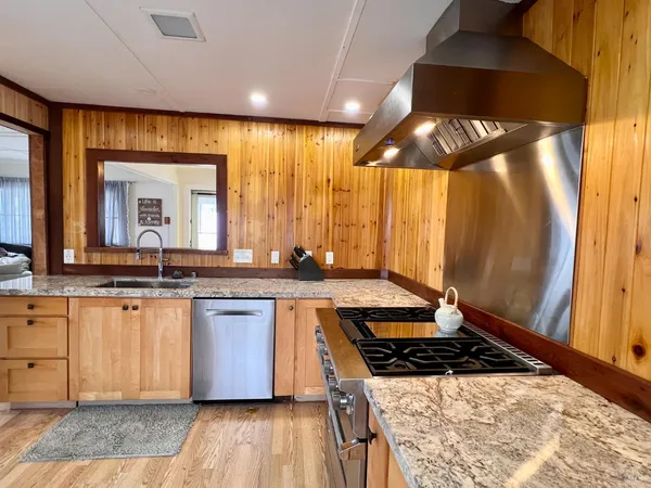 a kitchen with stainless steel appliances granite countertop a stove a sink and a microwave