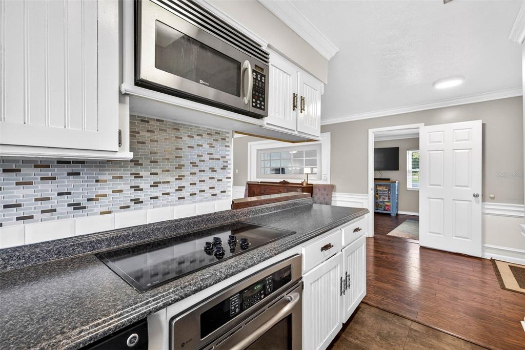 16330 Hanna Road Lutz, FL 33549 - Photo 12 of 41 a kitchen with granite countertop cabinets stainless steel appliances and wooden floor