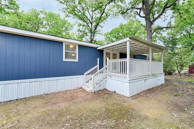 a view of backyard with small cabin and wooden fence