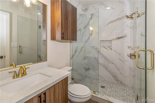 a bathroom with a sink toilet vanity and shower