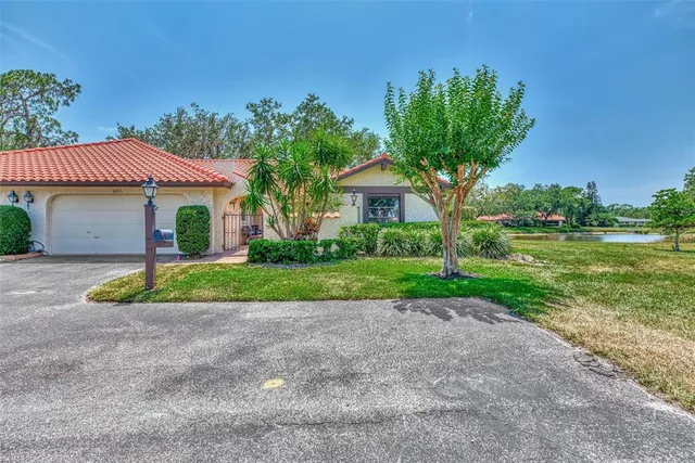 a front view of a house with a yard and potted plants