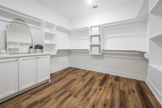 a view of a kitchen with wooden floor and electronic appliances