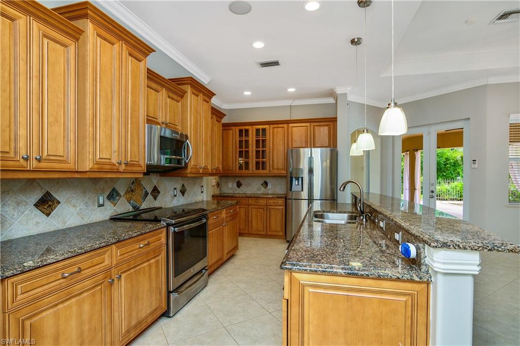 4430 Pine Ridge Road Naples, FL 34119 - Photo 13 of 35 a kitchen with stainless steel appliances granite countertop a sink a stove and a wooden cabinets