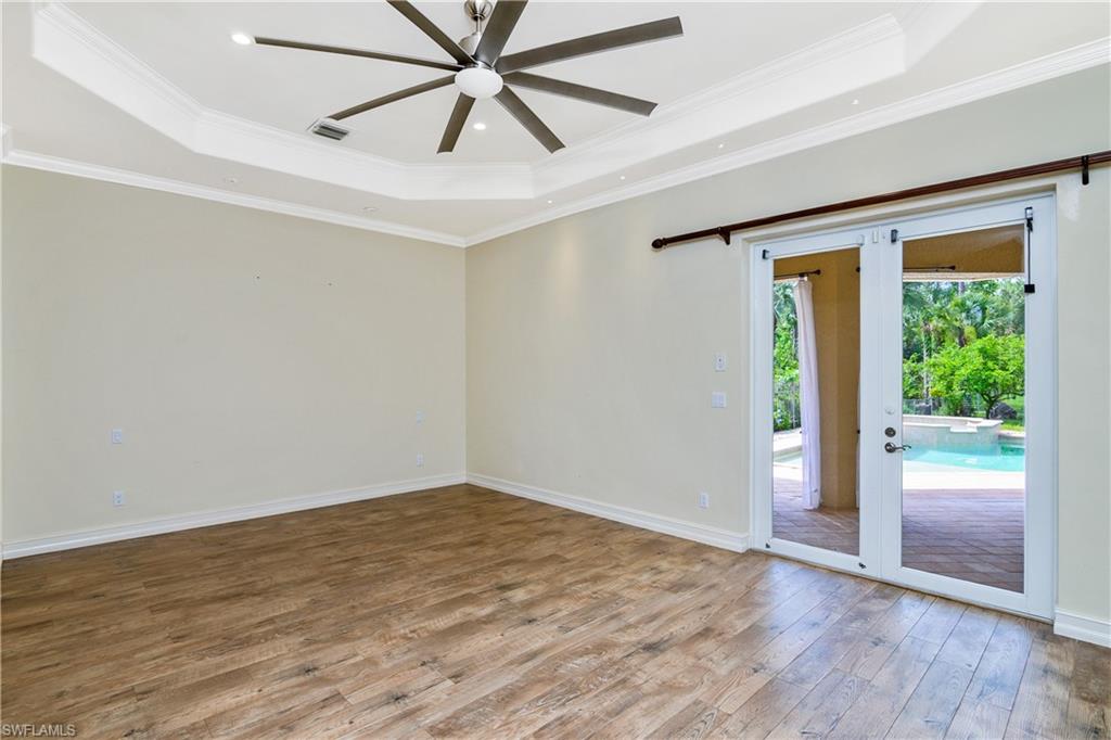 4430 Pine Ridge Road Naples, FL 34119 - Photo 19 of 35 an empty room with wooden floor fan and windows