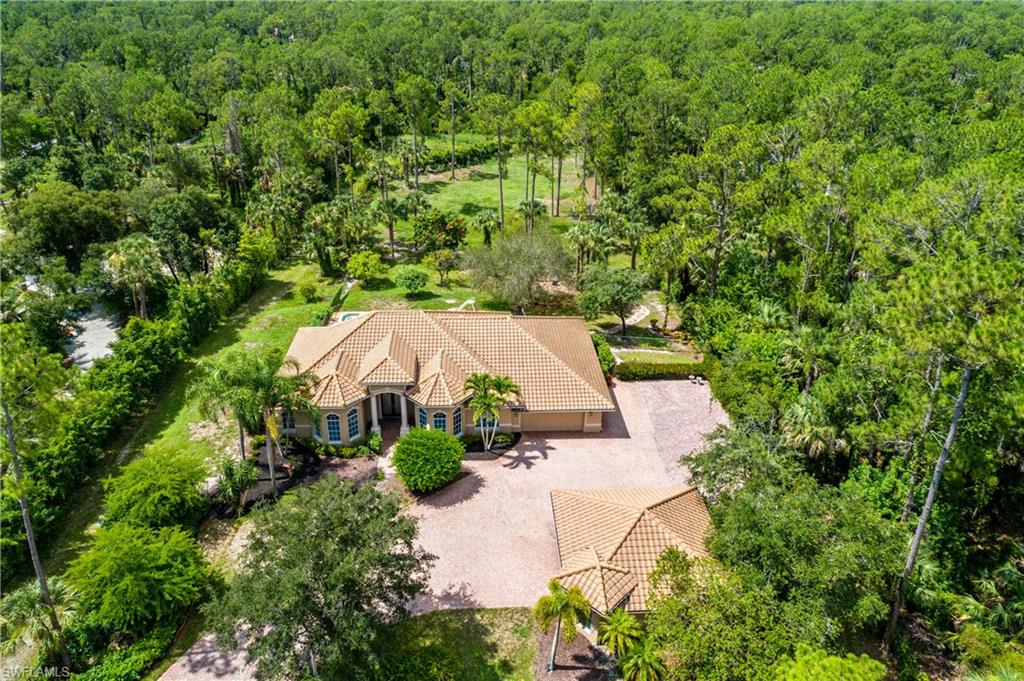 4430 Pine Ridge Road Naples, FL 34119 - Photo 2 of 35 an aerial view of a house with yard and outdoor seating