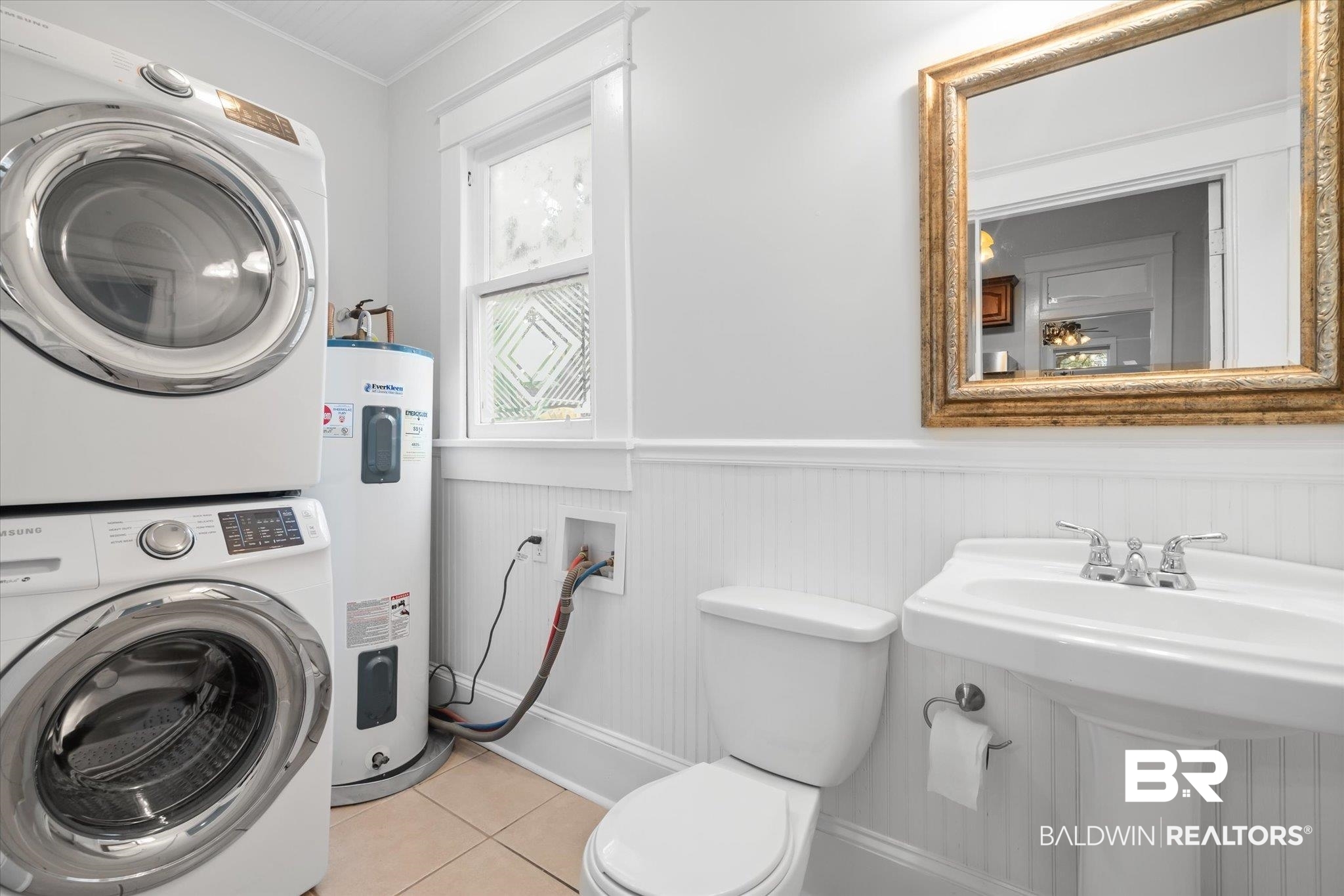 14 South Monterey Street Mobile, AL 36604 - Photo 17 of 41 Interior space with stacked washer and clothes dryer, ornamental molding, water heater, tile patterned floors, and toilet