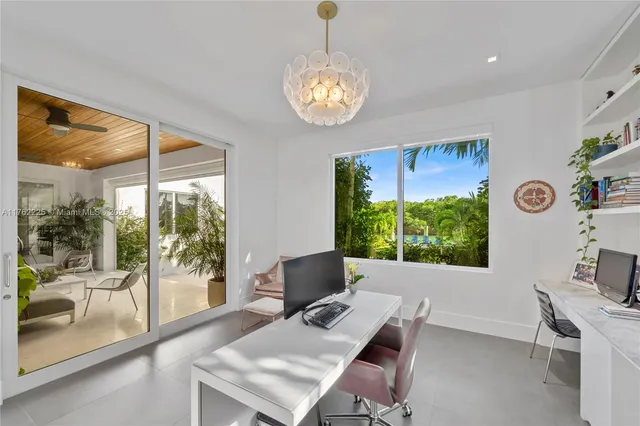 a bedroom with a balcony a bed and a flat tv screen next to a window