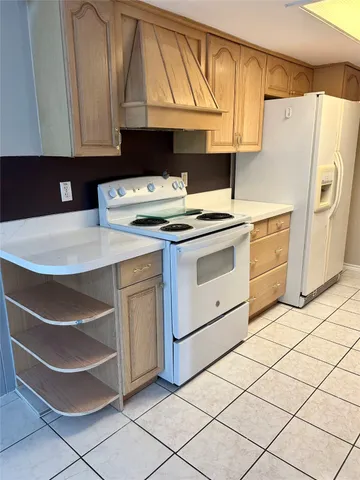 a kitchen with a stove cabinets and a refrigerator