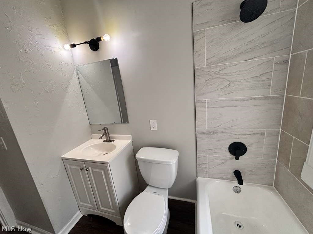 907 Rondel Road Cleveland, OH 44110 - Photo 10 of 26 Bathroom featuring a white vanity with integrated sink, white toilet, and a white bathtub