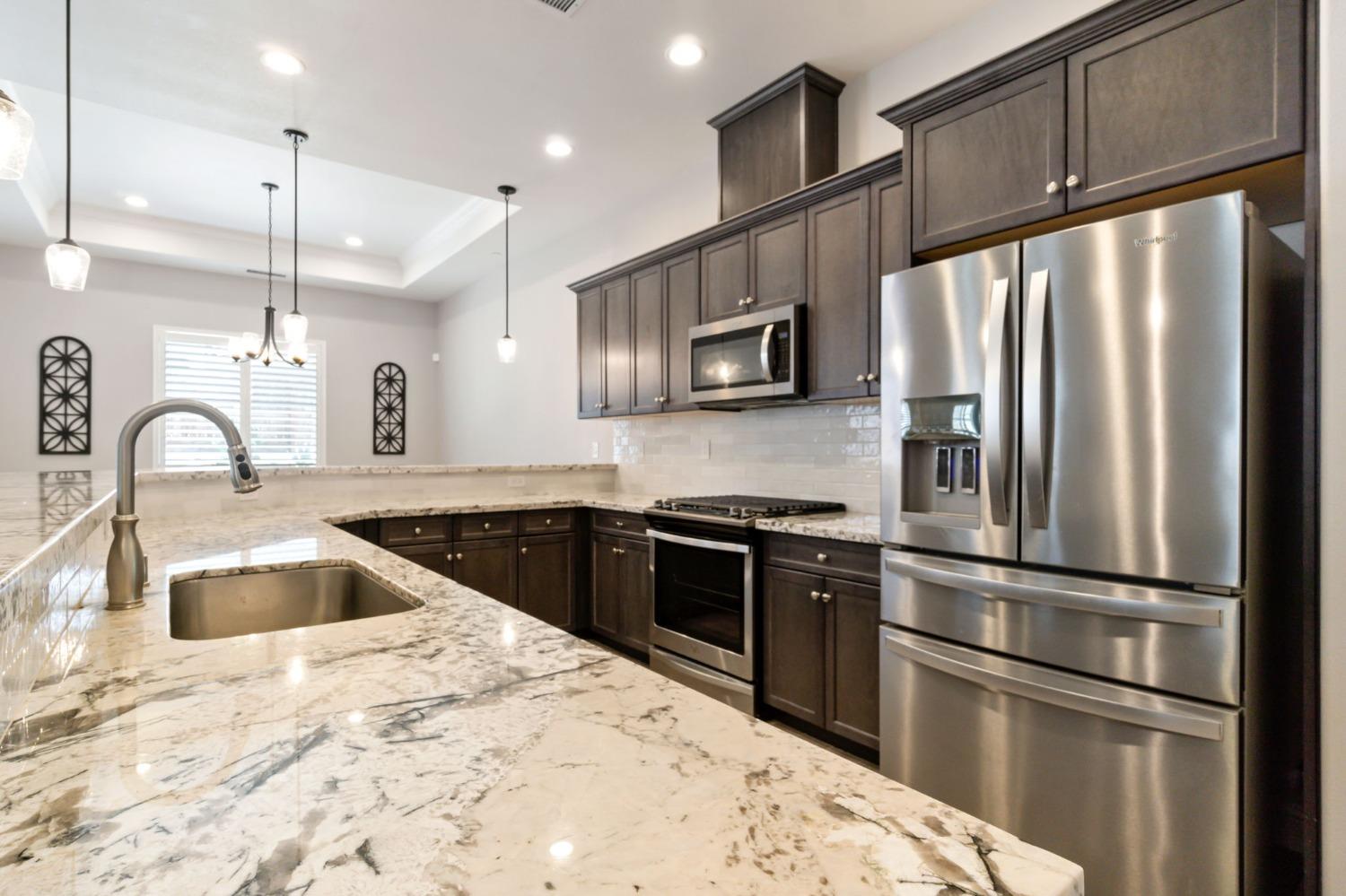 639 Mesa Drive Madera, CA 93636 - Photo 12 of 33 a kitchen with granite countertop a refrigerator stove and sink
