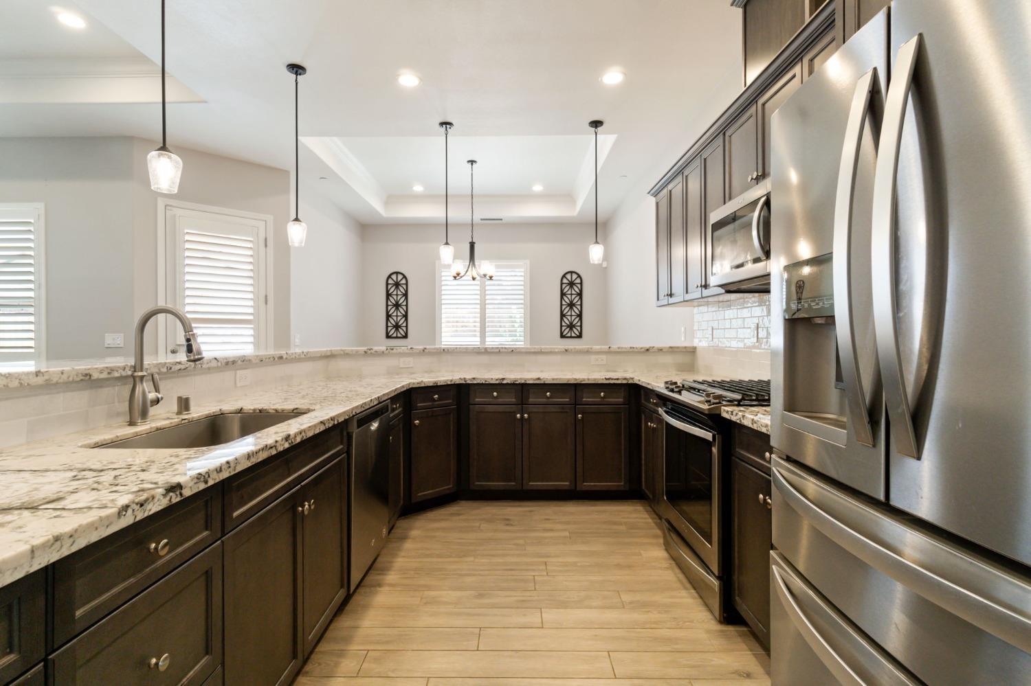 639 Mesa Drive Madera, CA 93636 - Photo 13 of 33 a large kitchen with stainless steel appliances granite countertop a sink and a refrigerator