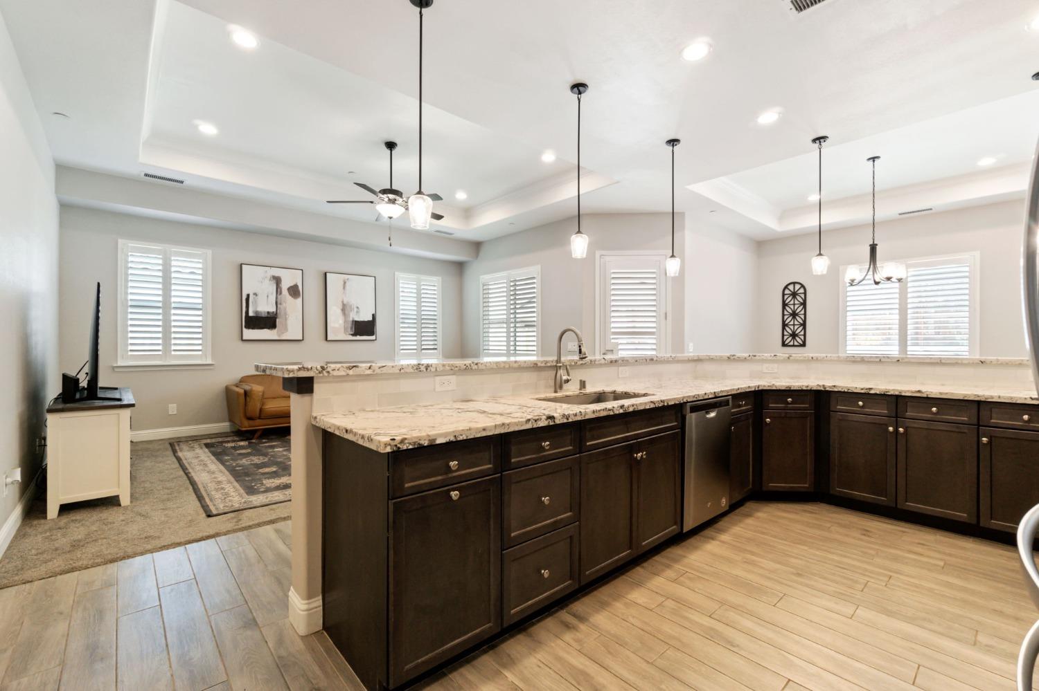 639 Mesa Drive Madera, CA 93636 - Photo 14 of 33 a large kitchen with a stove a sink dishwasher and a wooden cabinets with wooden floor