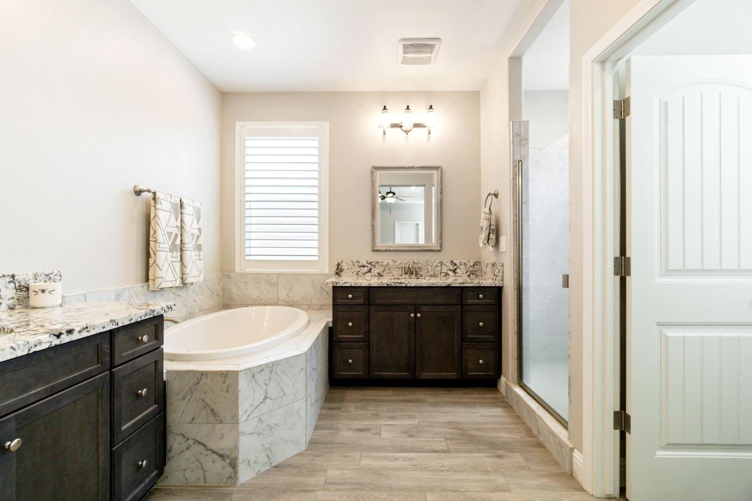 639 Mesa Drive Madera, CA 93636 - Photo 23 of 33 a spacious bathroom with a bathtub double sink and mirror