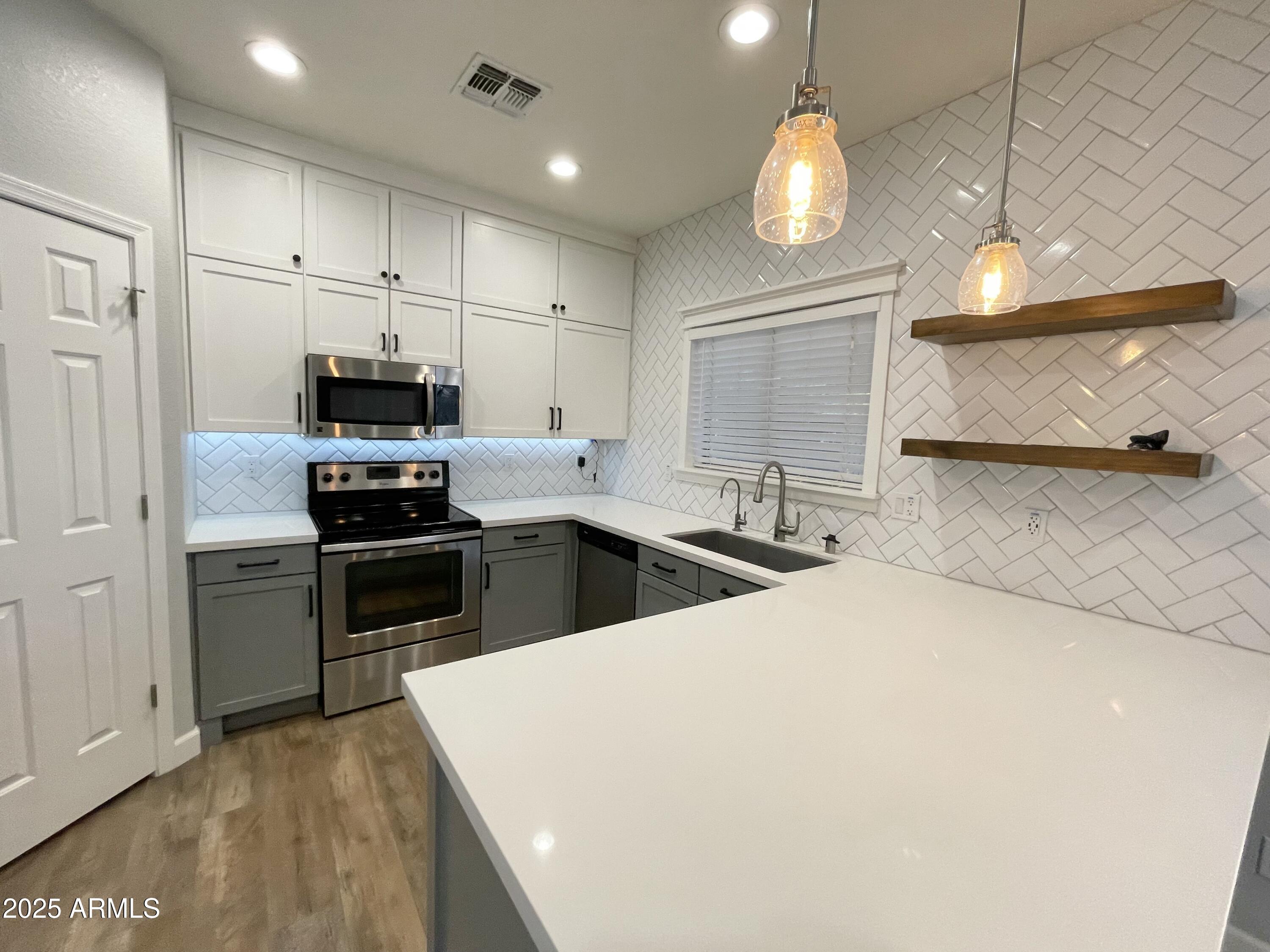 2640 East Indian Wells Place Chandler, AZ 85249 - Photo 11 of 40 a kitchen with stainless steel appliances a stove sink and refrigerator