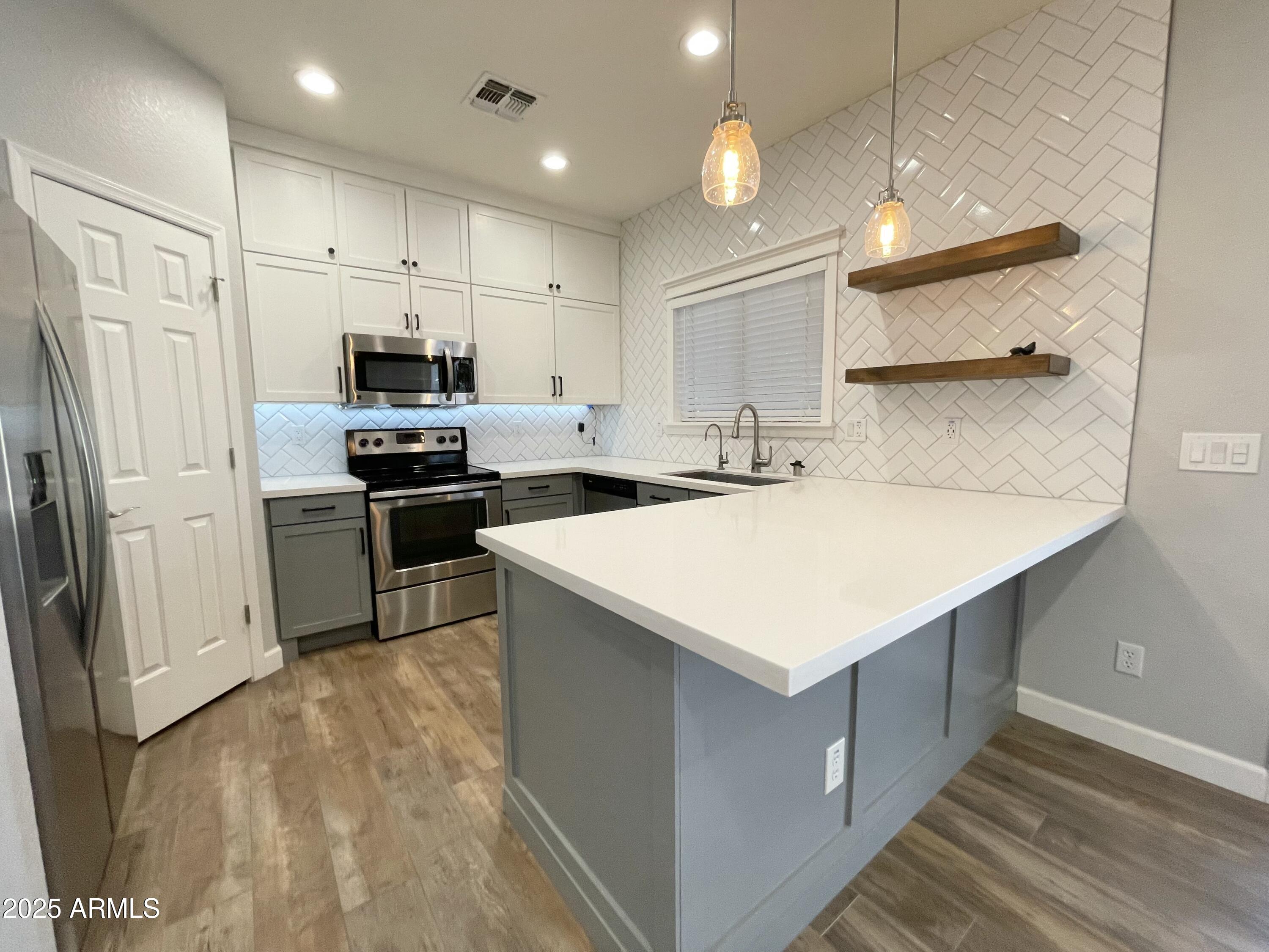 2640 East Indian Wells Place Chandler, AZ 85249 - Photo 14 of 40 a kitchen that has a lot of cabinets in it and stainless steel appliances