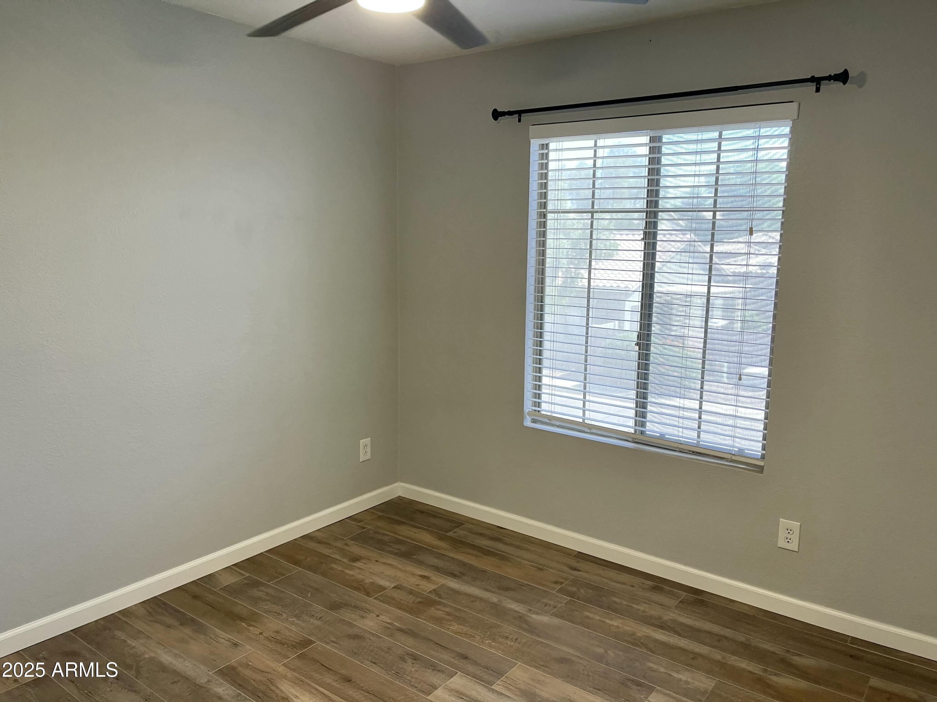 2640 East Indian Wells Place Chandler, AZ 85249 - Photo 23 of 40 a view of an empty room with wooden floor and a window