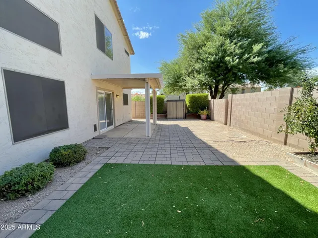 a front view of a house with a yard and potted plants
