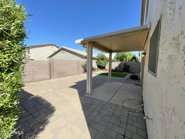 a patio with table and chairs and potted plants