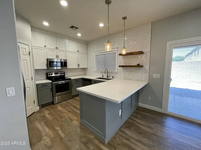 a kitchen with kitchen island a sink stainless steel appliances and counter space