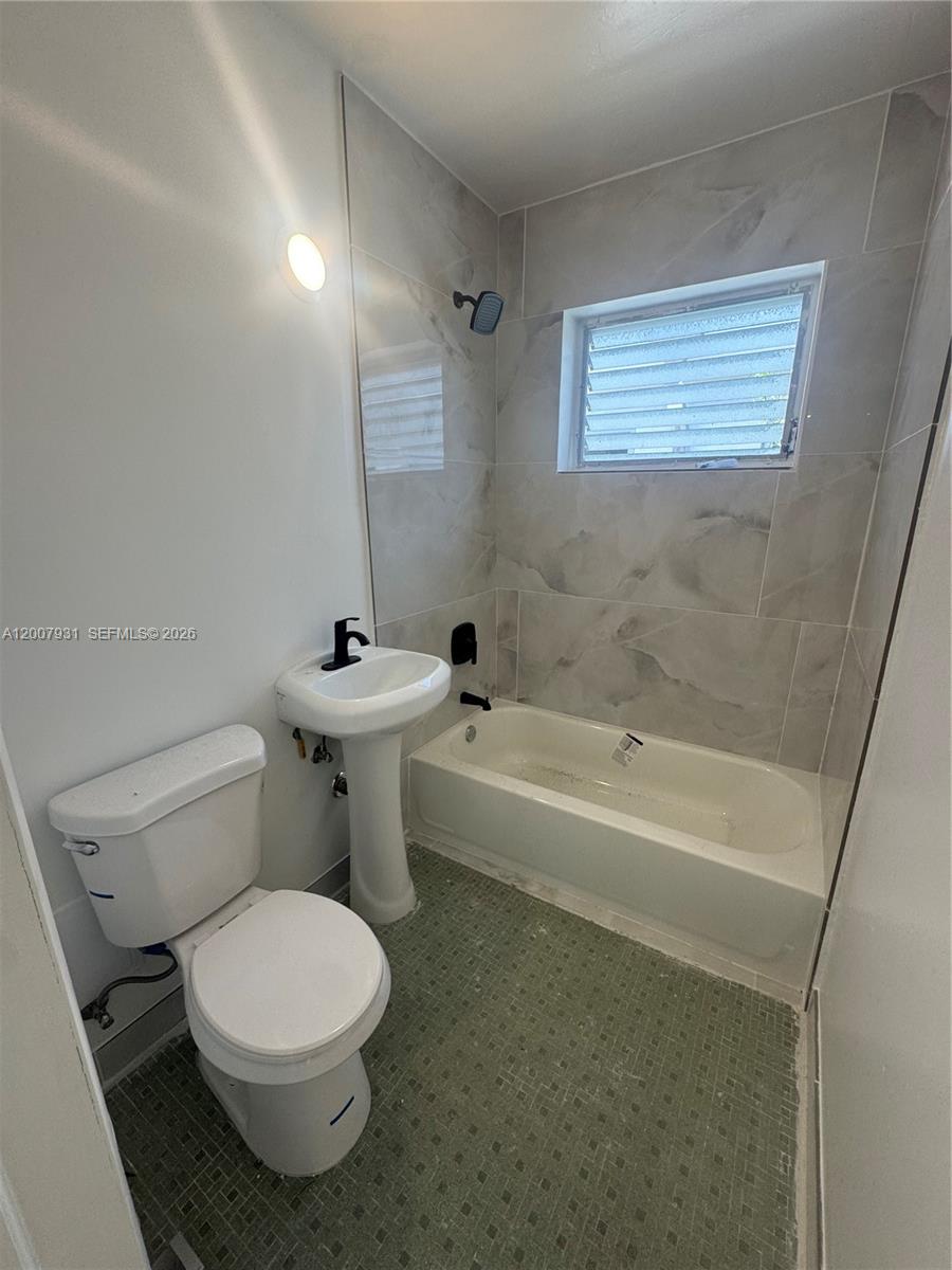 7300 Harding Avenue, Unit 21 Miami Beach, FL 33141 - Photo 5 of 6 a bathroom with a toilet a sink and bathtub