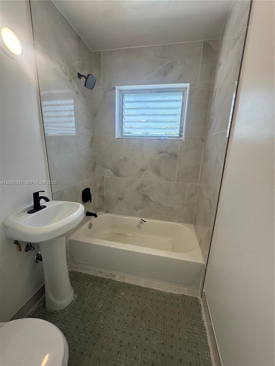 7300 Harding Avenue, Unit 21 Miami Beach, FL 33141 - Photo 6 of 6 a bathroom with a sink a toilet and shower