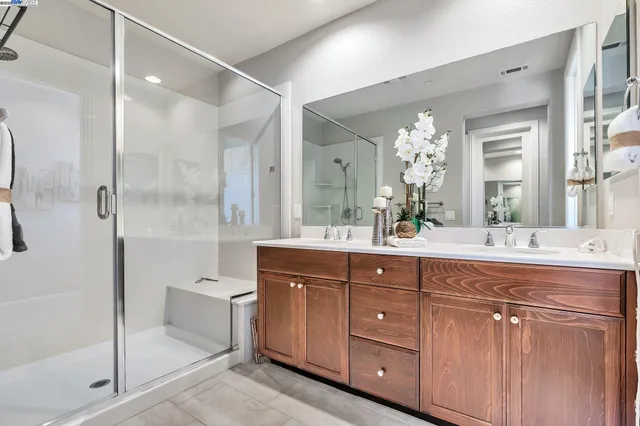 a bathroom with a granite countertop sink mirror and a bathtub