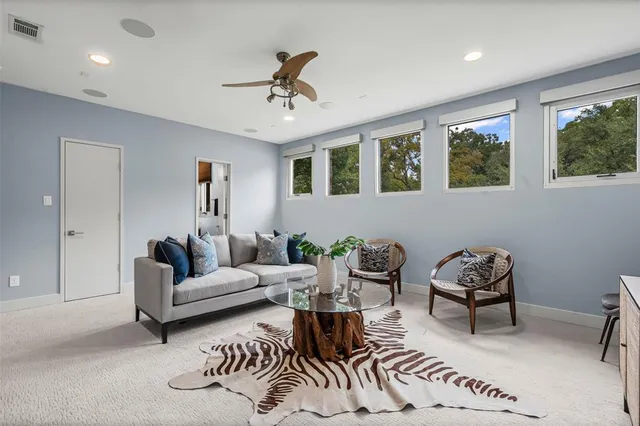 a living room with furniture and a ceiling fan