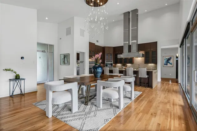 a view of a dining room with furniture a chandelier and wooden floor