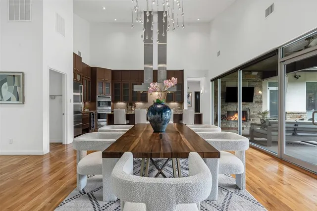 a view of a dining room with furniture a kitchen and chandelier