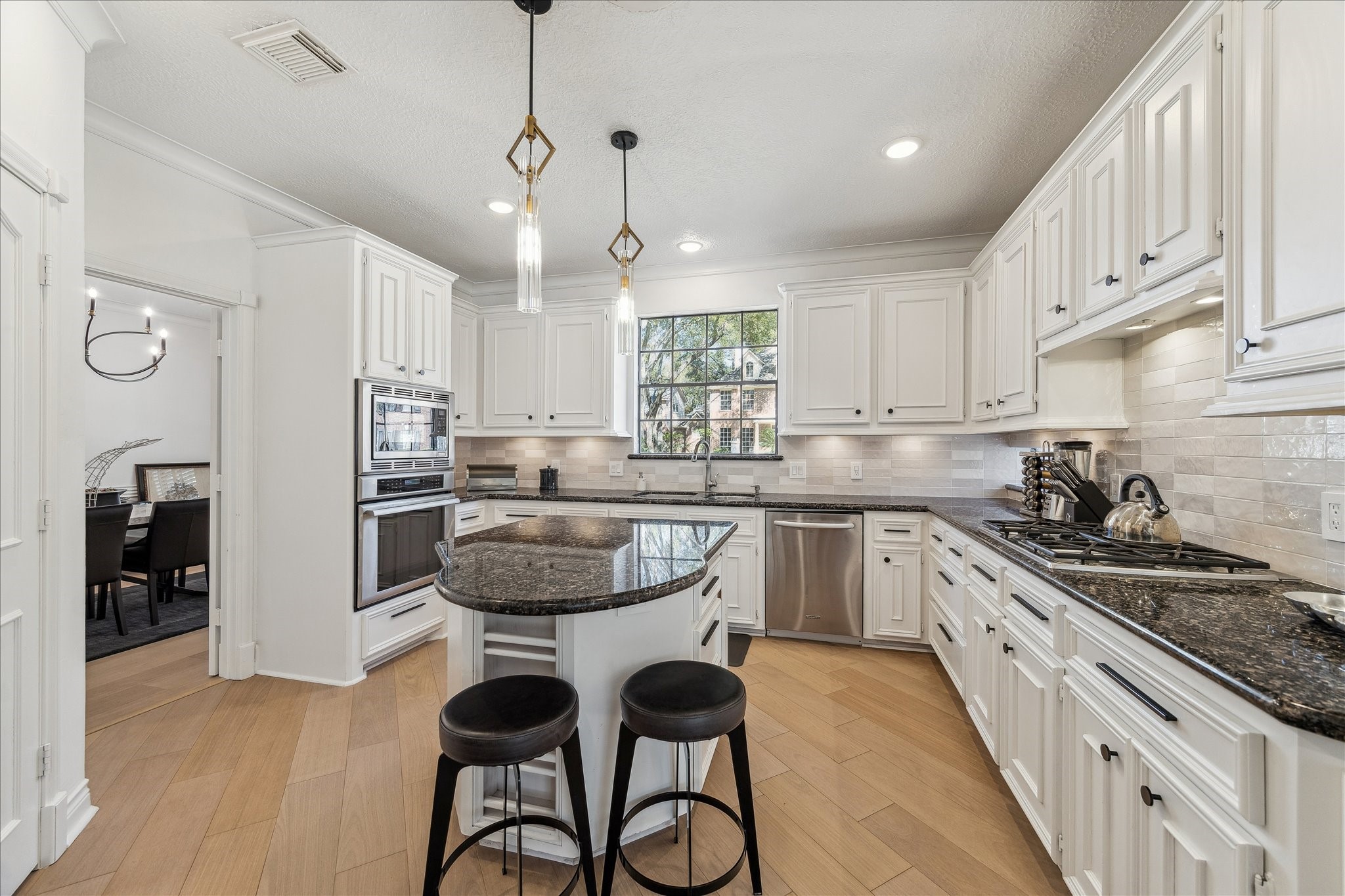 6787 Monarda Court Houston, TX 77069 - Photo 6 of 33 a kitchen with stainless steel appliances granite countertop a stove a sink dishwasher a refrigerator and white cabinets with wooden floor