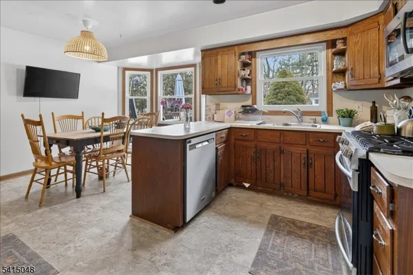 a kitchen with a table chairs refrigerator and cabinets