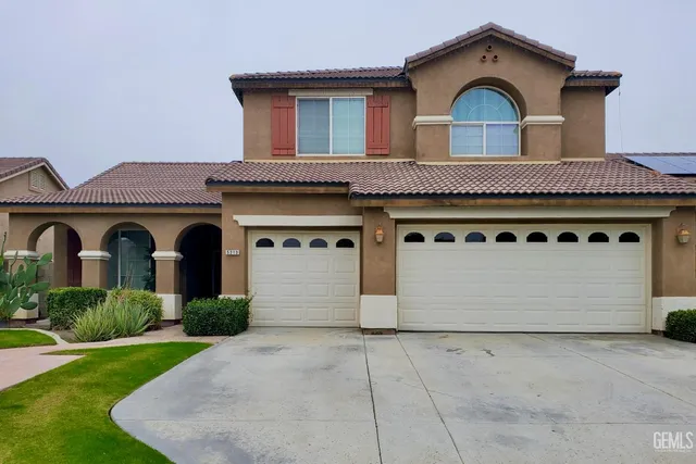 a front view of a house with a garden and garage