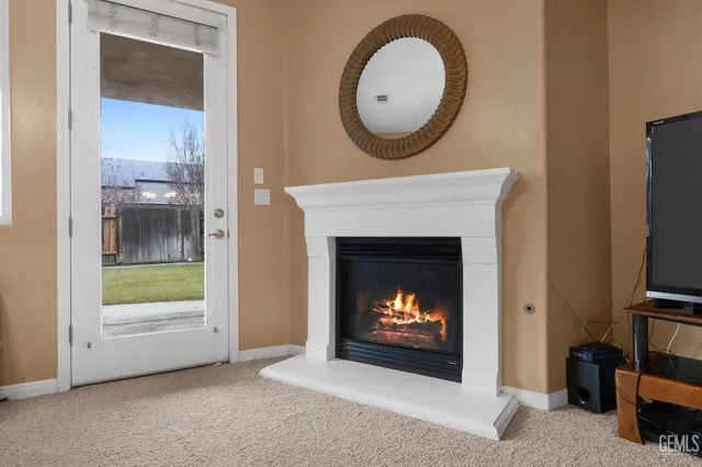 a living room with furniture a fireplace and a large window