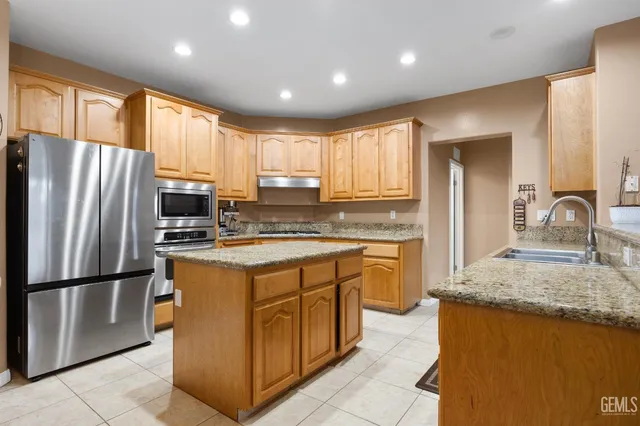 a kitchen with granite countertop a sink a stove and cabinets