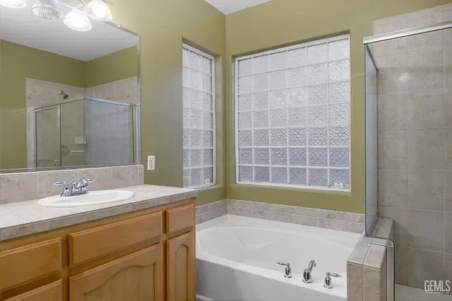 a bathroom with a sink a toilet a mirror and shower