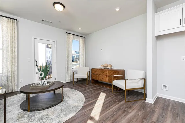 a living room with furniture and a wooden floor