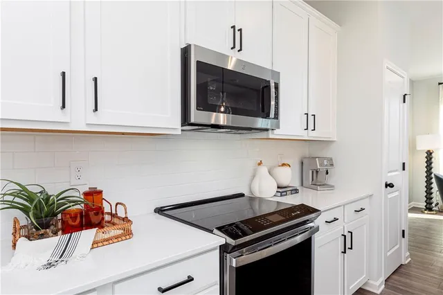 a kitchen with stainless steel appliances white cabinets and a stove