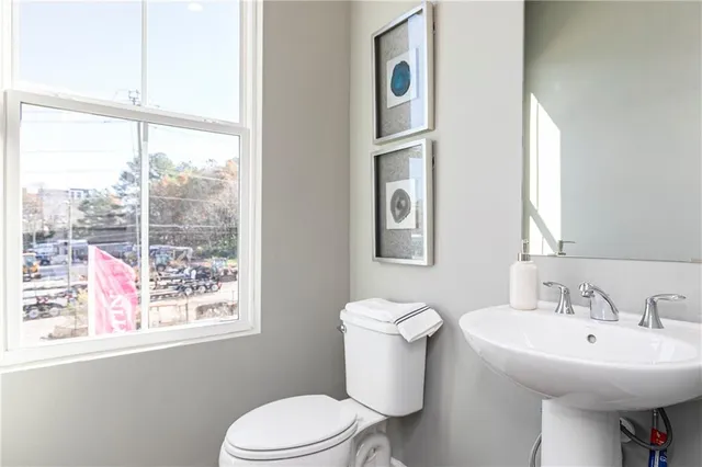 a bathroom with a sink toilet and a mirror