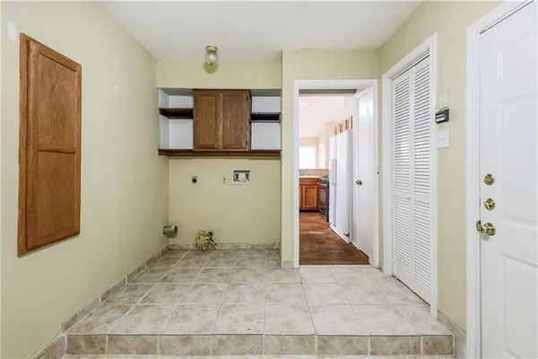 a view of a hallway with wooden floor and cabinet