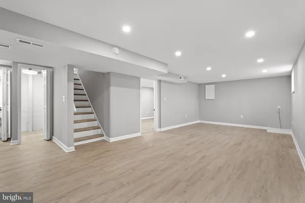 an empty room with wooden floor and entryway