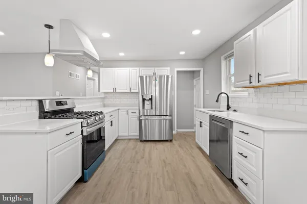 a kitchen with granite countertop a sink stainless steel appliances and cabinets
