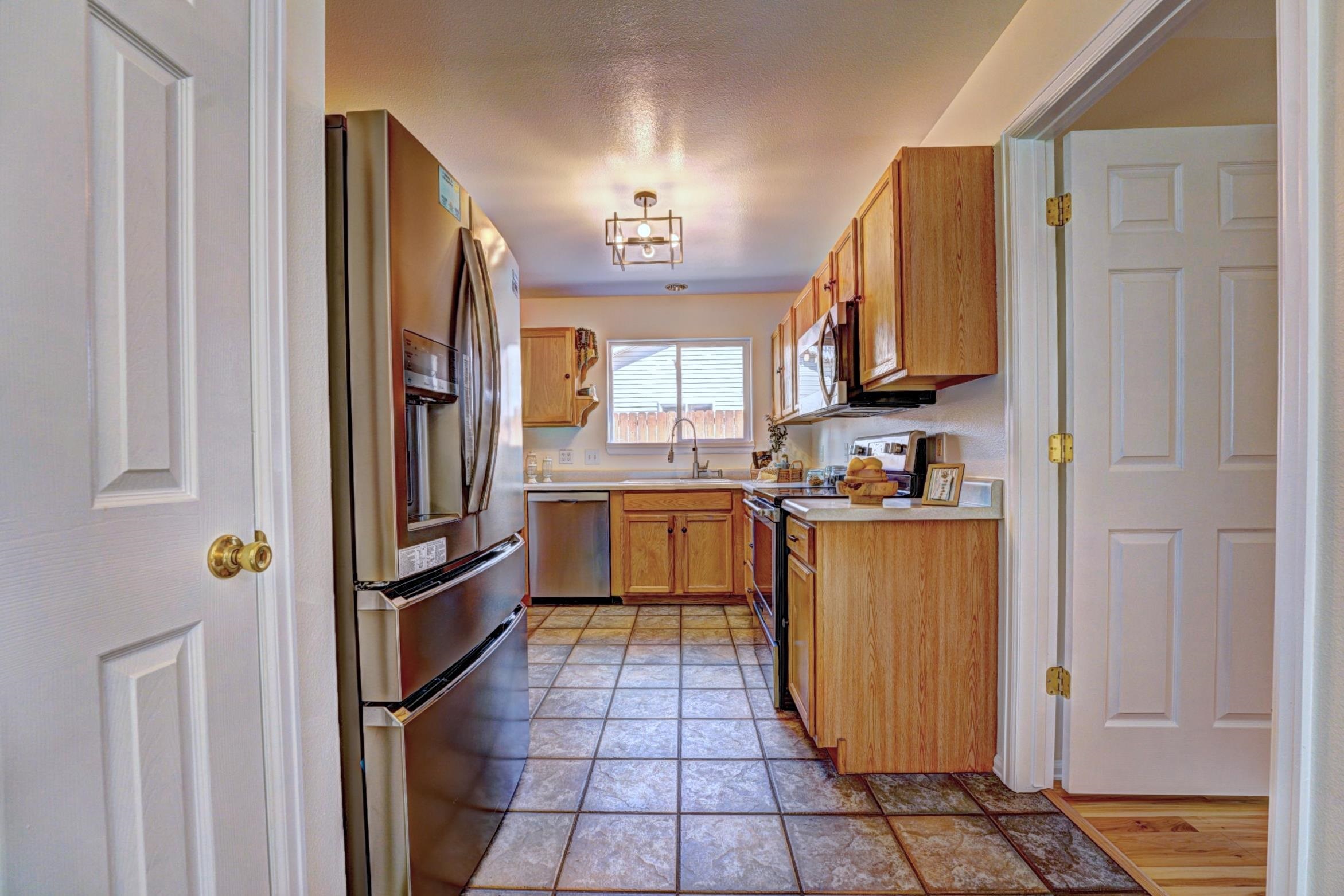 1460 Powell Street Fruita, CO 81521 - Photo 13 of 35 a kitchen with stainless steel appliances granite countertop a refrigerator and a stove top oven
