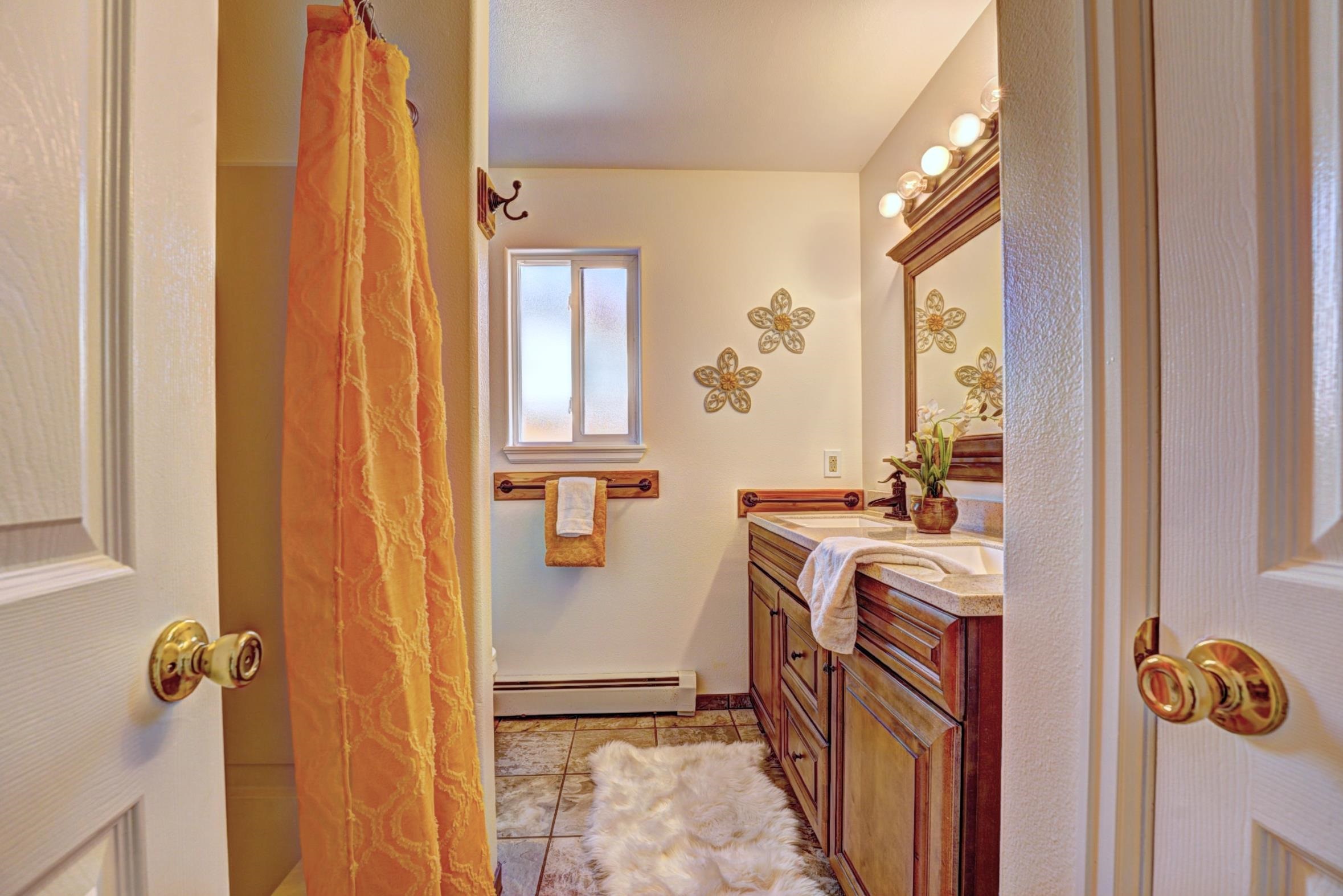 1460 Powell Street Fruita, CO 81521 - Photo 22 of 35 a bathroom with a sink a mirror a window and a shower