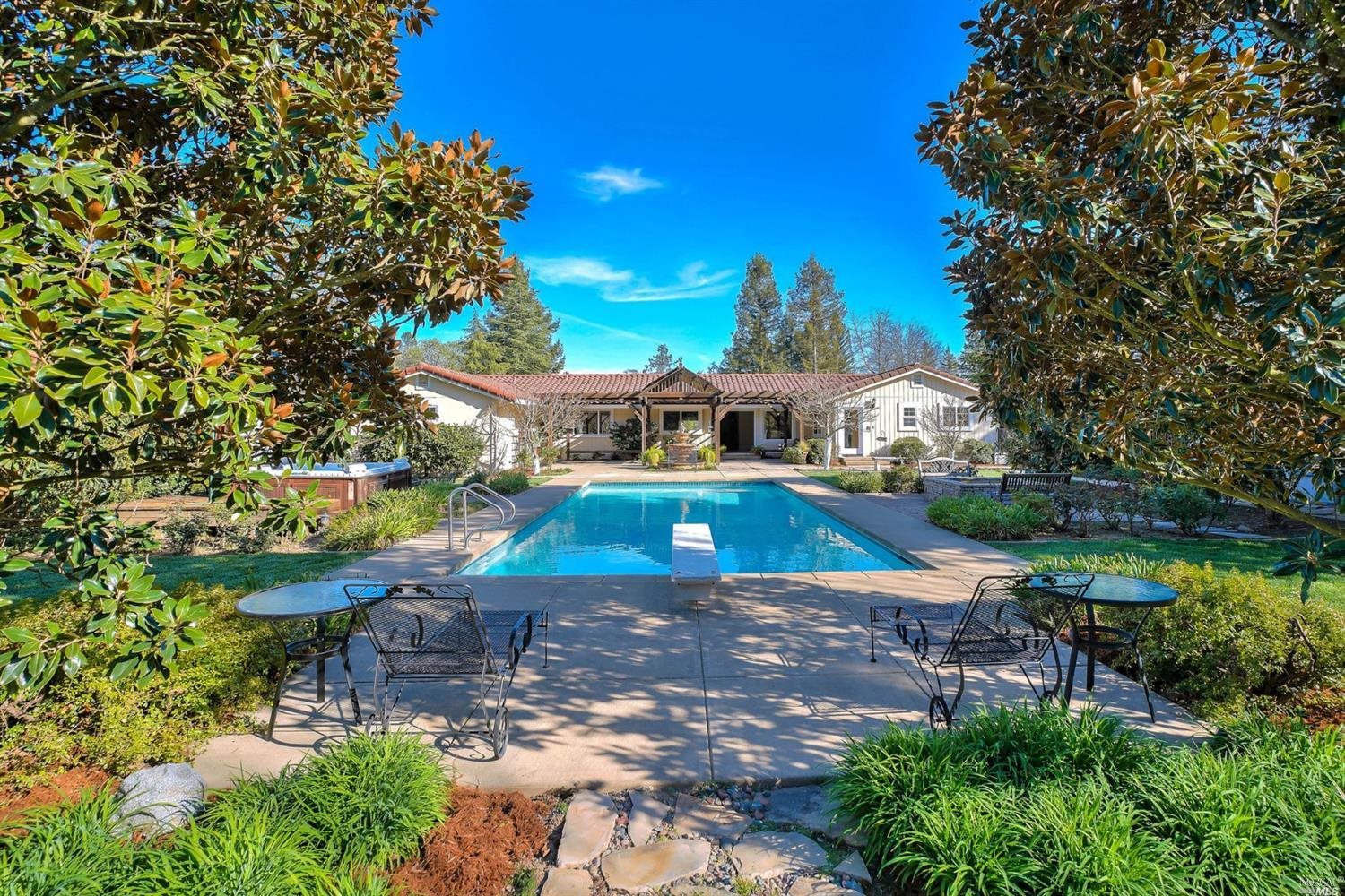 an aerial view of a house with swimming pool garden view and trees
