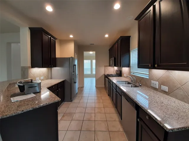 a large kitchen with granite countertop lots of counter space and a sink