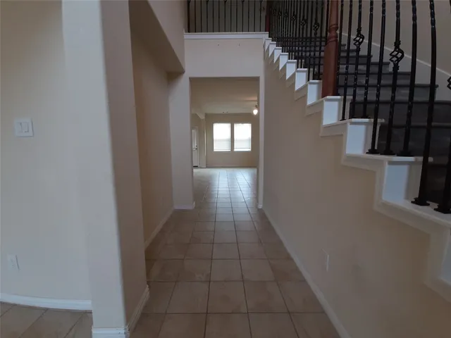 a hallway with wooden floor windows and a kitchen view