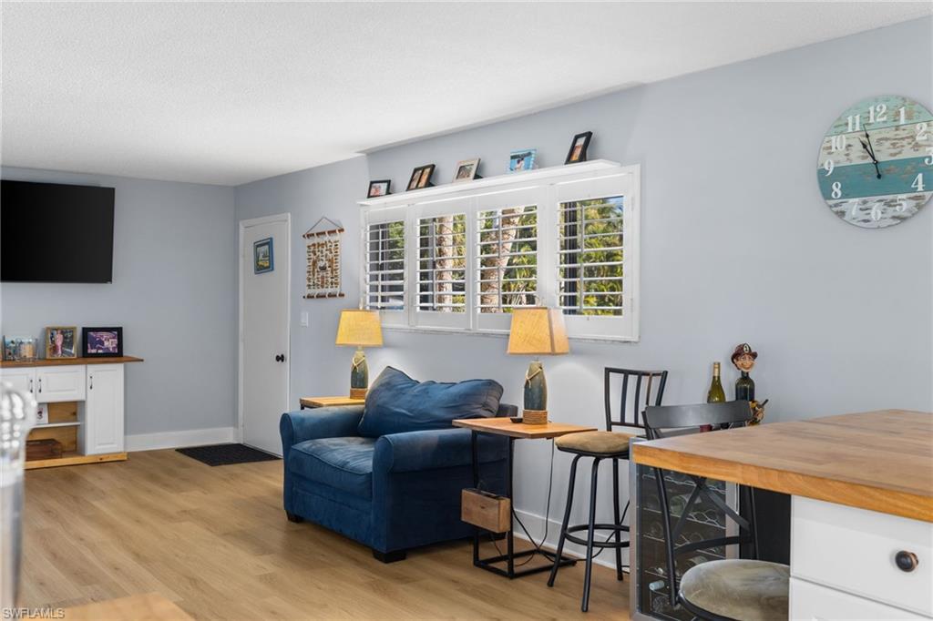 1686 Blue Point Avenue, Unit A1 Naples, FL 34102 - Photo 15 of 38 a living room with furniture and a flat screen tv