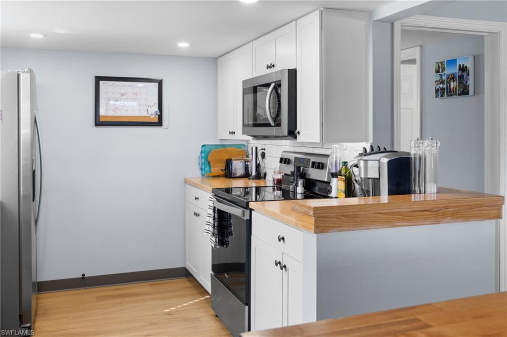 1686 Blue Point Avenue, Unit A1 Naples, FL 34102 - Photo 17 of 38 a kitchen with stainless steel appliances granite countertop a refrigerator and a stove top oven
