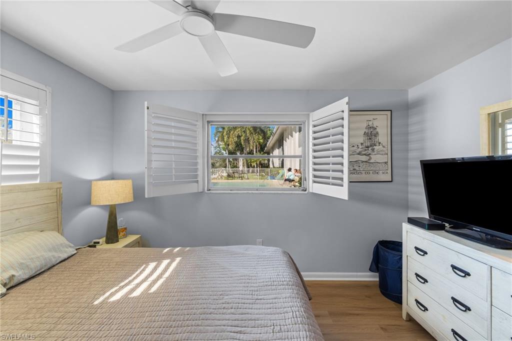 1686 Blue Point Avenue, Unit A1 Naples, FL 34102 - Photo 21 of 38 a bedroom with a bed and a flat screen tv